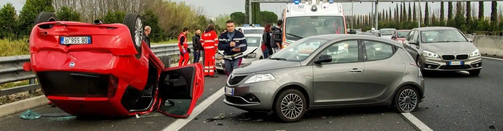 Flipped red car in the aftermath of a multi car accident.