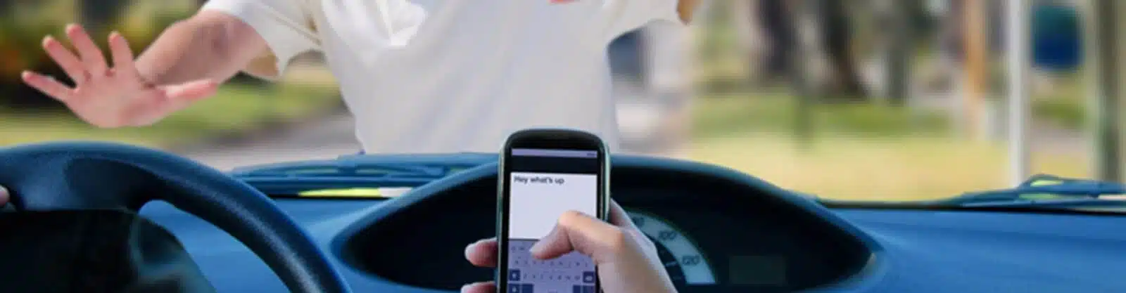 man about to be hit by a car because the driver is on their phone.